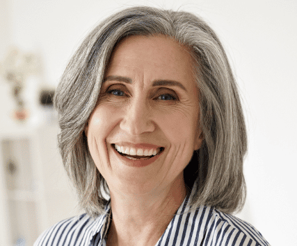 A woman with grey hair smiling for the camera.
